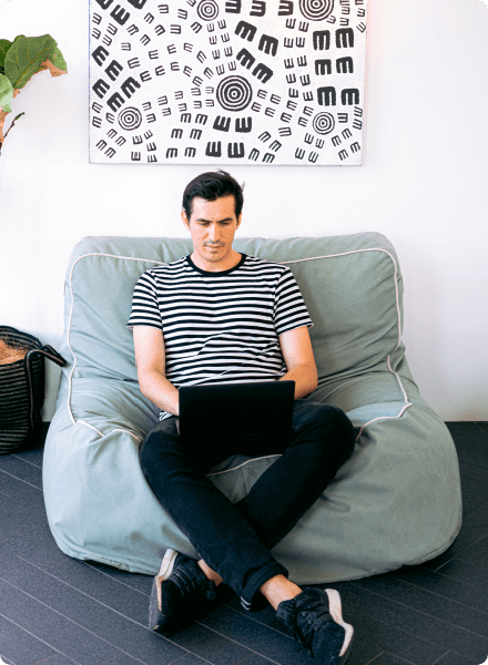 Guy in striped shirt sitting with laptop